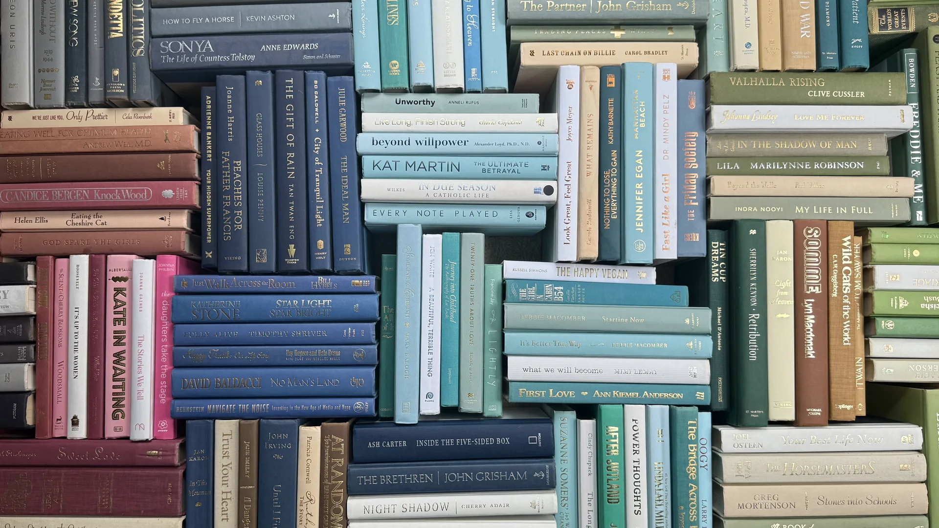 Overhead view of books arranged in layered groups of cream, rose, blue, and green